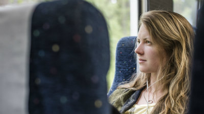 Kvinna tittar ut genom tågfönstret